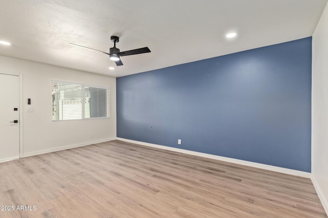 unfurnished room with a textured ceiling, ceiling fan, and light wood-type flooring