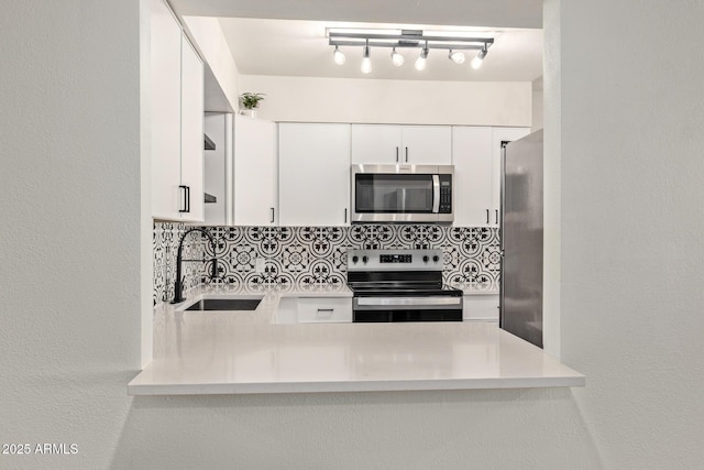 kitchen featuring white cabinetry, appliances with stainless steel finishes, sink, and backsplash