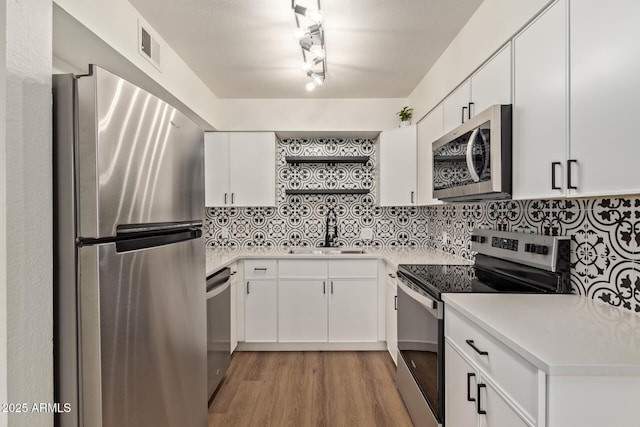 kitchen featuring tasteful backsplash, sink, stainless steel appliances, and white cabinets