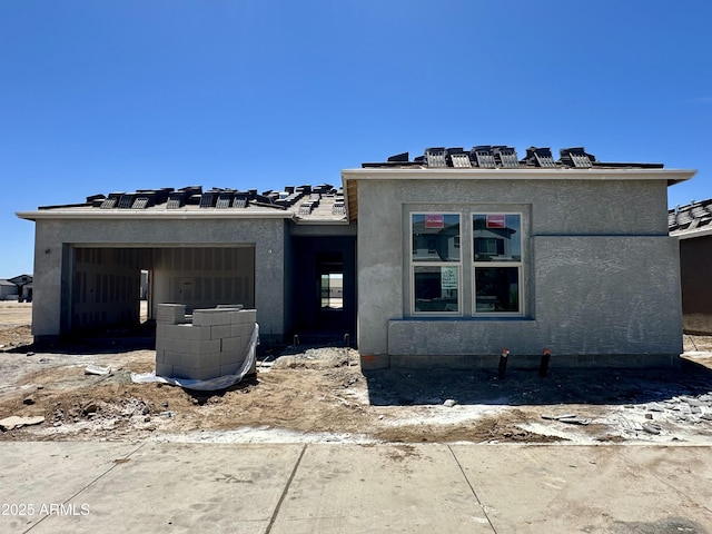 property in mid-construction with an attached garage and stucco siding