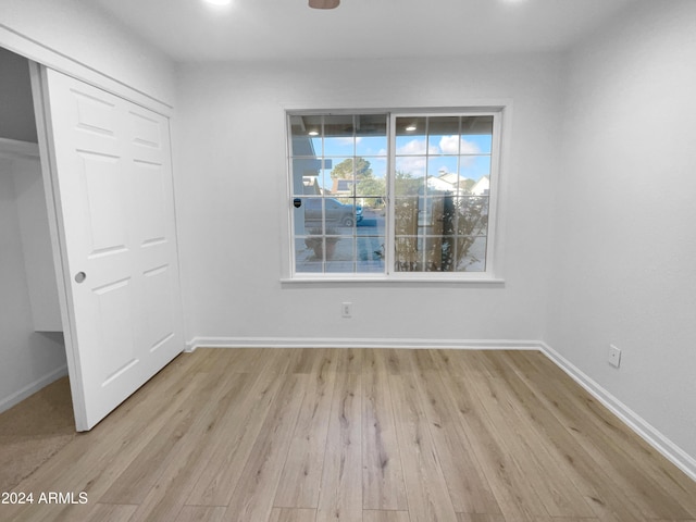 unfurnished bedroom featuring light hardwood / wood-style floors and a closet