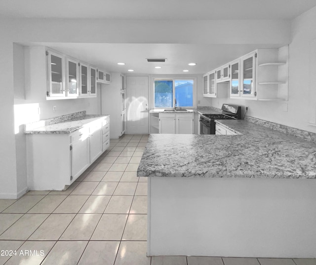 kitchen featuring white cabinetry, sink, black gas range oven, kitchen peninsula, and light tile patterned floors