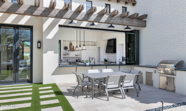 view of patio featuring sink, a pergola, area for grilling, french doors, and an outdoor kitchen