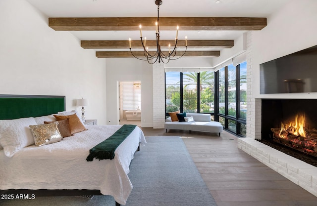 bedroom featuring a fireplace, a chandelier, and hardwood / wood-style floors