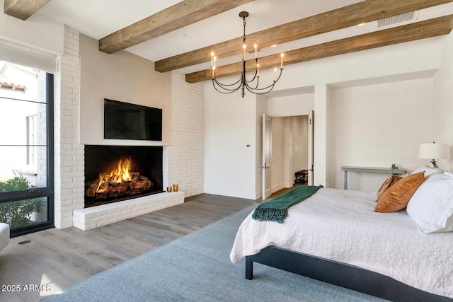 bedroom featuring hardwood / wood-style flooring, a fireplace, beam ceiling, and a notable chandelier