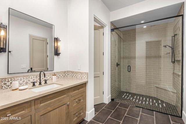 bathroom with a shower with door, vanity, tile patterned floors, and decorative backsplash