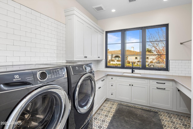 washroom featuring separate washer and dryer, sink, and cabinets