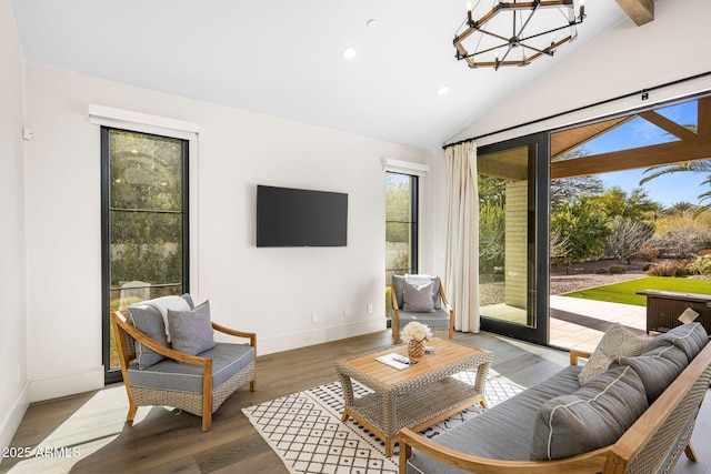 living room with lofted ceiling, hardwood / wood-style floors, and a chandelier