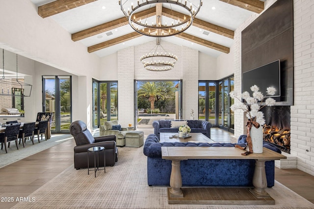 living room featuring hardwood / wood-style flooring, a fireplace, a chandelier, and high vaulted ceiling