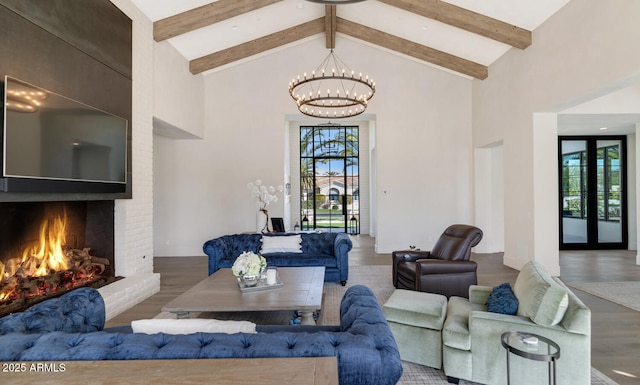 living room with hardwood / wood-style floors, a notable chandelier, high vaulted ceiling, and french doors