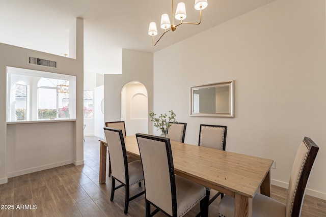 dining area featuring dark wood-type flooring and a chandelier