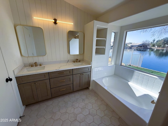 bathroom with vanity, tile patterned flooring, a bathing tub, and a water view