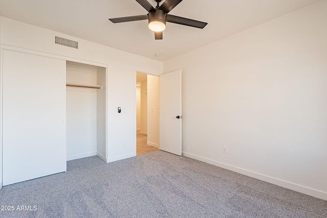 unfurnished bedroom with ceiling fan, carpet flooring, and a closet