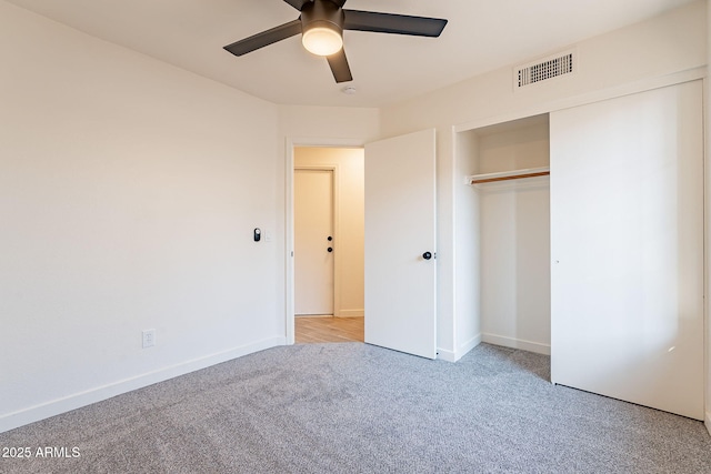 unfurnished bedroom with ceiling fan, light colored carpet, and a closet