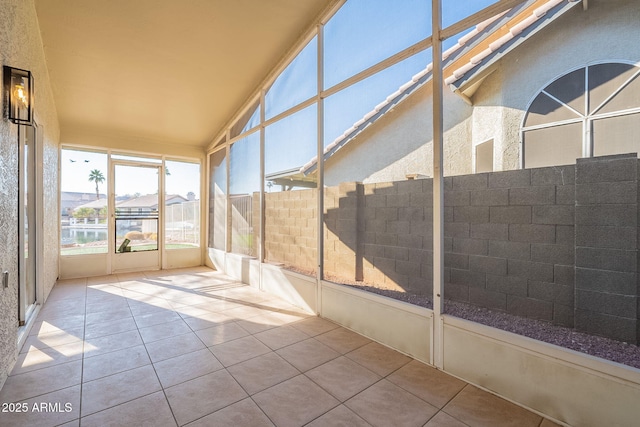 unfurnished sunroom featuring a water view and vaulted ceiling