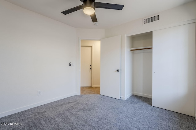 unfurnished bedroom featuring ceiling fan, a closet, and light carpet