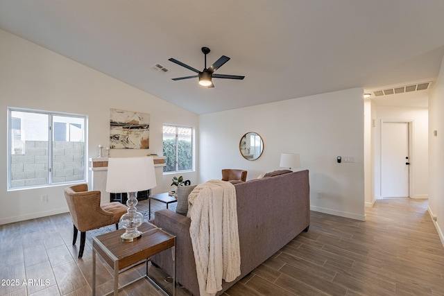 living room with hardwood / wood-style flooring, ceiling fan, lofted ceiling, and a brick fireplace