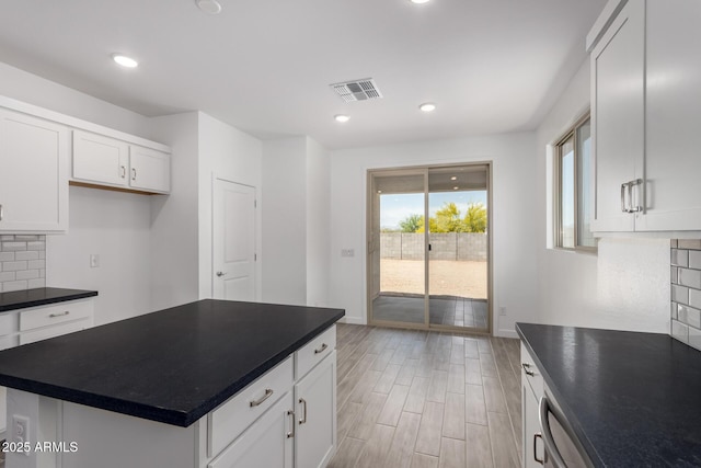 kitchen with dark countertops, backsplash, baseboards, light wood-style flooring, and recessed lighting