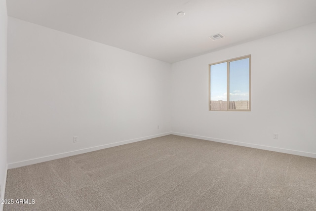 carpeted empty room featuring baseboards