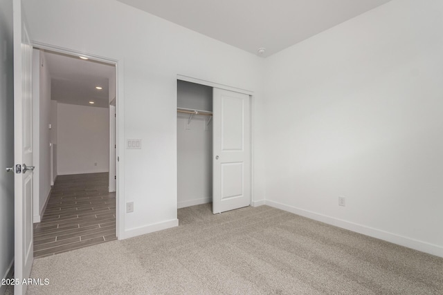 unfurnished bedroom featuring a closet, baseboards, carpet, and recessed lighting