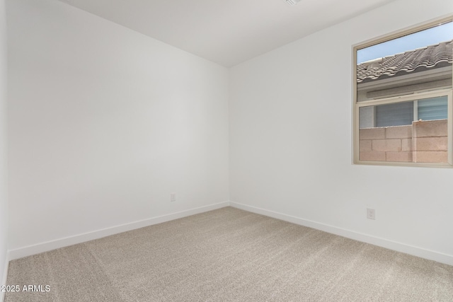 carpeted spare room featuring baseboards