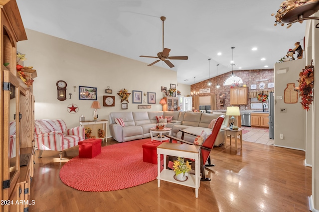 living room featuring ceiling fan, light hardwood / wood-style flooring, vaulted ceiling, and sink