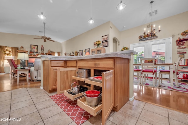 kitchen with french doors, light hardwood / wood-style flooring, high vaulted ceiling, decorative light fixtures, and ceiling fan with notable chandelier