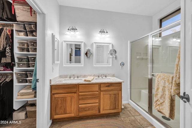 bathroom featuring tile patterned floors, vanity, and a shower with shower door