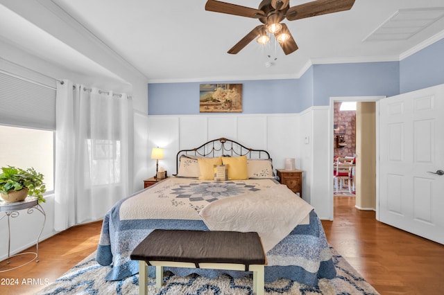 bedroom with hardwood / wood-style flooring, ceiling fan, and ornamental molding