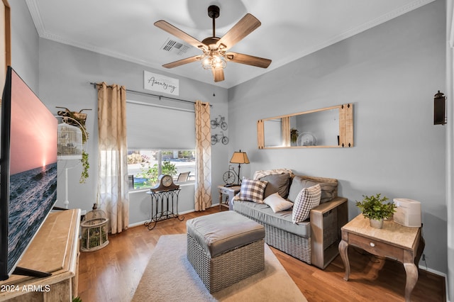 living room with ceiling fan, light wood-type flooring, and ornamental molding