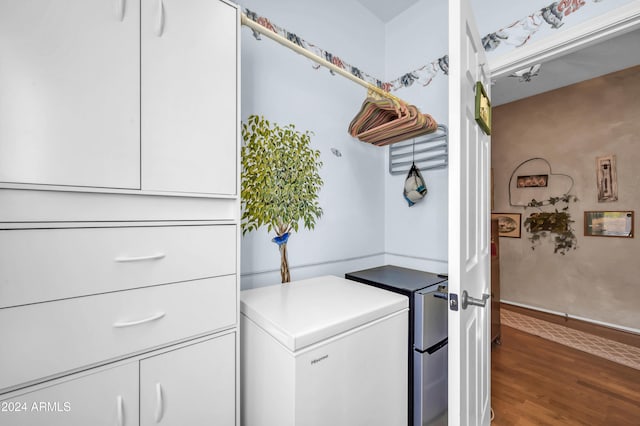 laundry room featuring dark hardwood / wood-style floors, cabinets, and separate washer and dryer