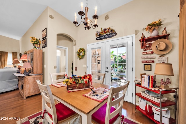 dining area featuring french doors, dark hardwood / wood-style floors, vaulted ceiling, and a notable chandelier