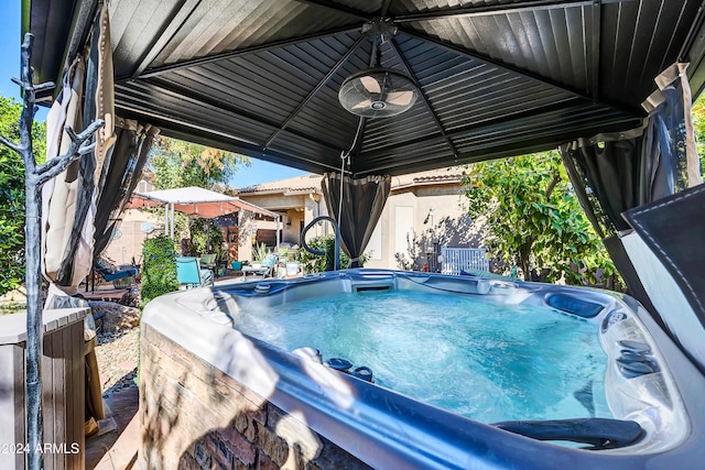 view of swimming pool featuring a gazebo and a hot tub