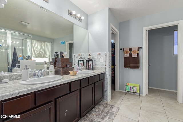 bathroom with tile patterned floors, vanity, and a shower with door