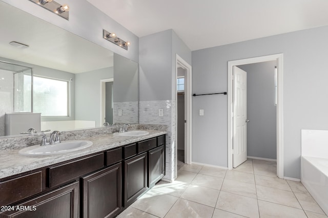 bathroom featuring tile patterned flooring, vanity, and a tub