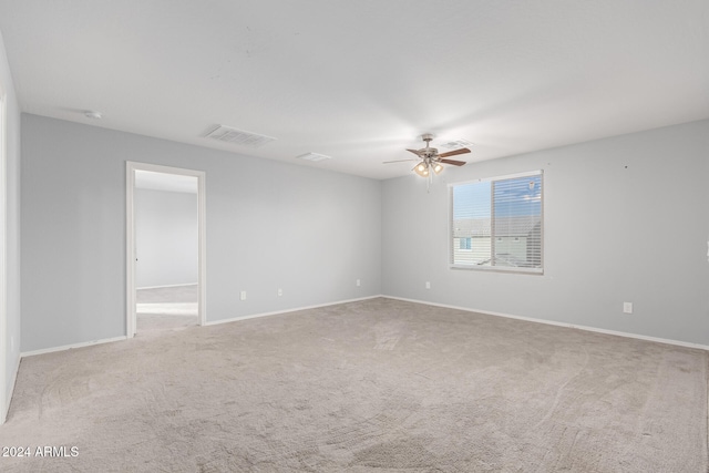 carpeted spare room with ceiling fan