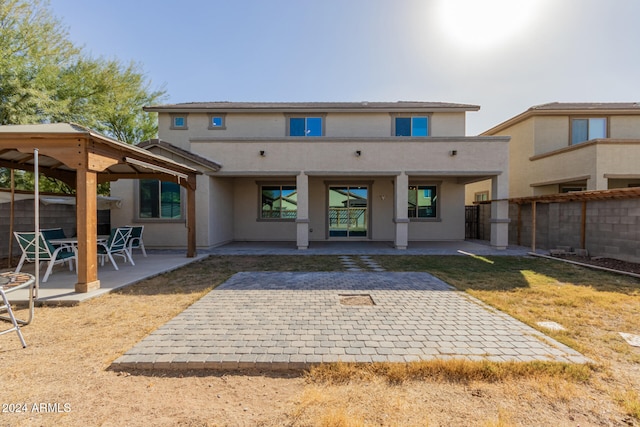 back of property featuring a gazebo and a patio