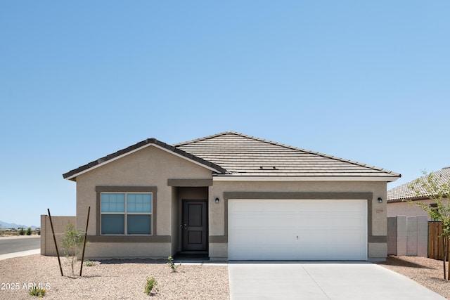 ranch-style house featuring driveway, fence, an attached garage, a tile roof, and stucco siding