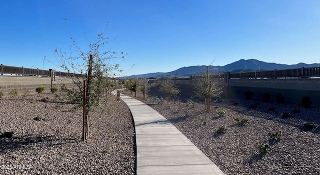 surrounding community with a mountain view and fence