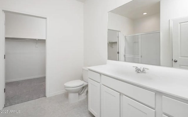 full bath with a spacious closet, toilet, vanity, and tile patterned floors