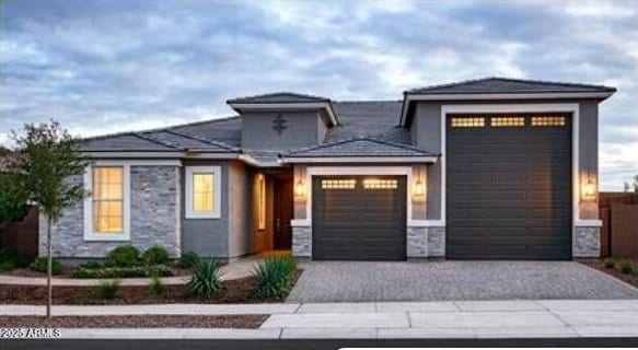 27665 N 176th Dr, Surprise, AZ 85387 - prairie-style house with stone siding, an attached garage, and decorative driveway