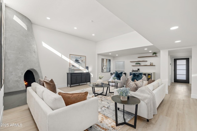 living room featuring a large fireplace and light hardwood / wood-style floors