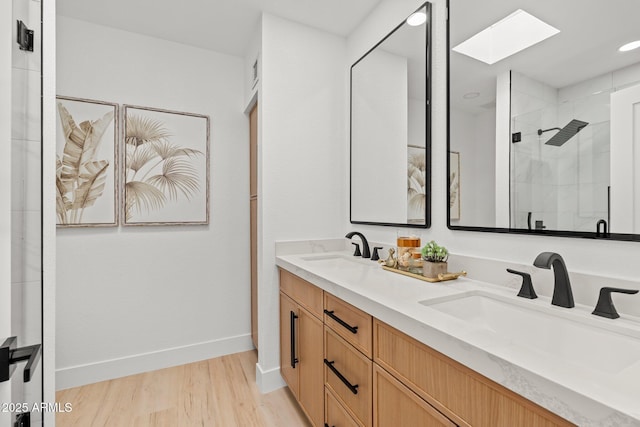 bathroom with vanity, a skylight, an enclosed shower, and hardwood / wood-style flooring