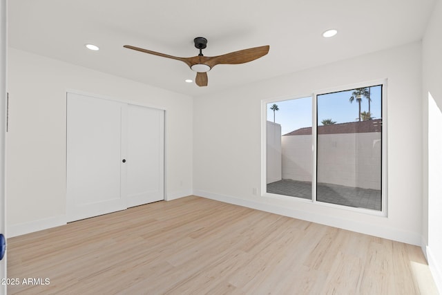 unfurnished bedroom featuring ceiling fan, light hardwood / wood-style floors, and a closet