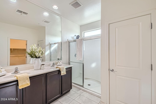 bathroom with tile patterned flooring, vanity, and a shower with shower door