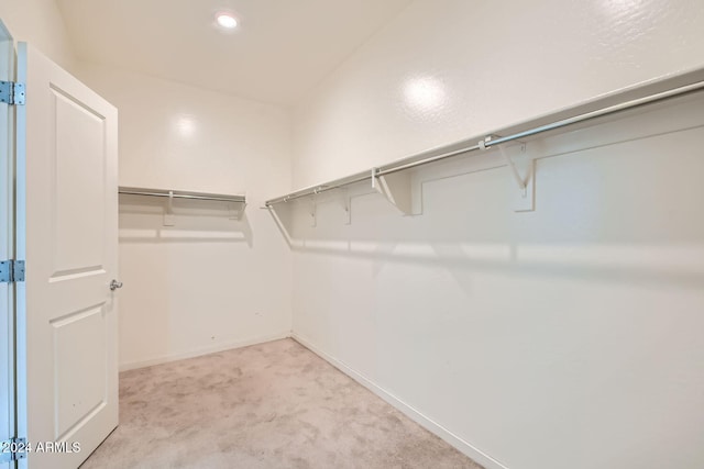 walk in closet featuring light carpet