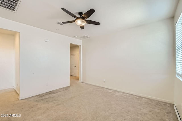 carpeted spare room featuring plenty of natural light and ceiling fan