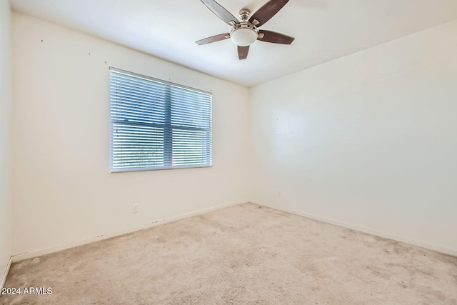 carpeted spare room featuring ceiling fan