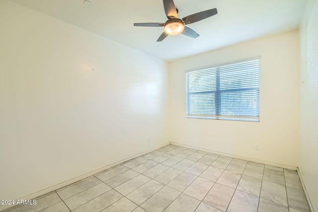 tiled spare room featuring ceiling fan