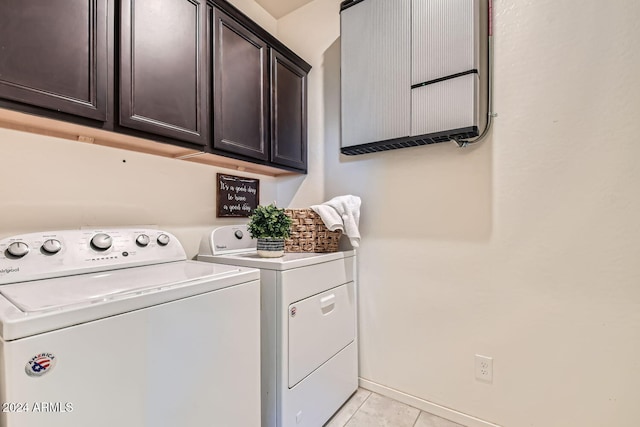 laundry room featuring cabinets, independent washer and dryer, and light tile patterned floors